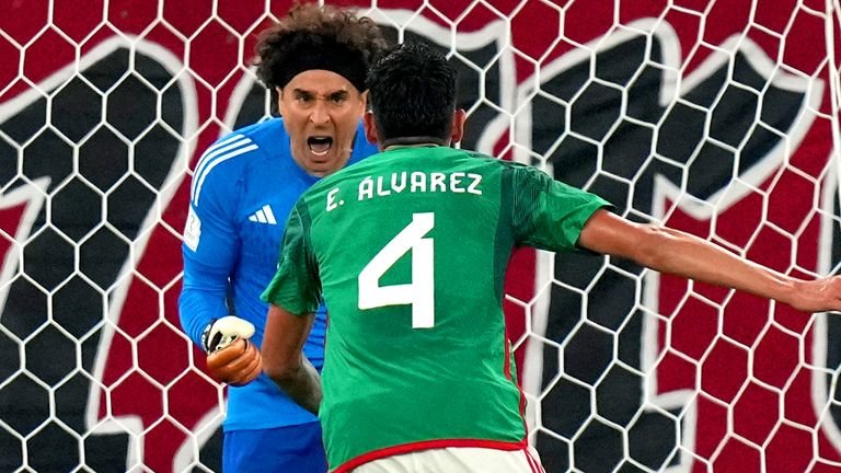 Guillermo Ochoa celebrates with team-mate Edson Alvarez after saving Robert Lewandowski's penalty