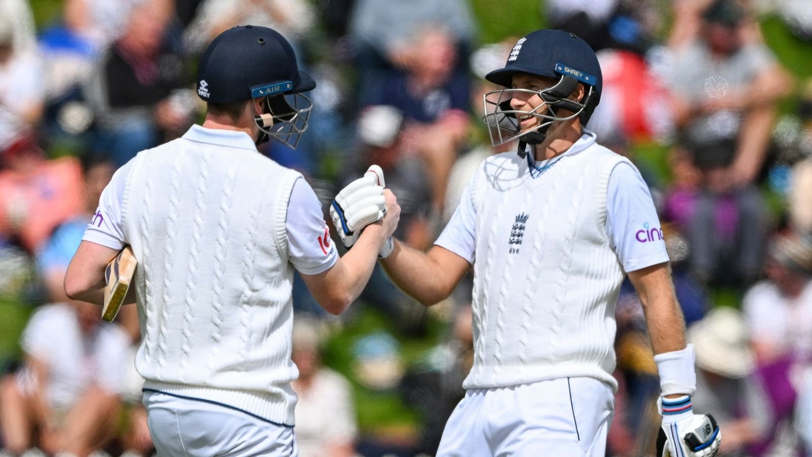 Joe Root, right, of England and Harry Brook celebrate their 200 run partnership on the first day of the second cricket test against New Zealand at the Basin Reserve in Wellington, New Zealand, Friday, Feb. 24, 2023. (Andrew Cornaga/Photosport via AP)