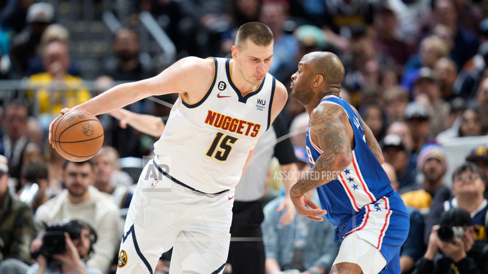 Denver Nuggets center Nikola Jokic, left, drives into Philadelphia 76ers forward P.J. Tucker.